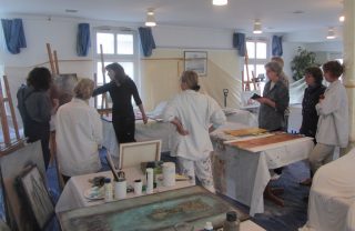 Bild von Teilnehmern und Renate Linnemeier im Atelier während einer Malreise nach Greetsiel